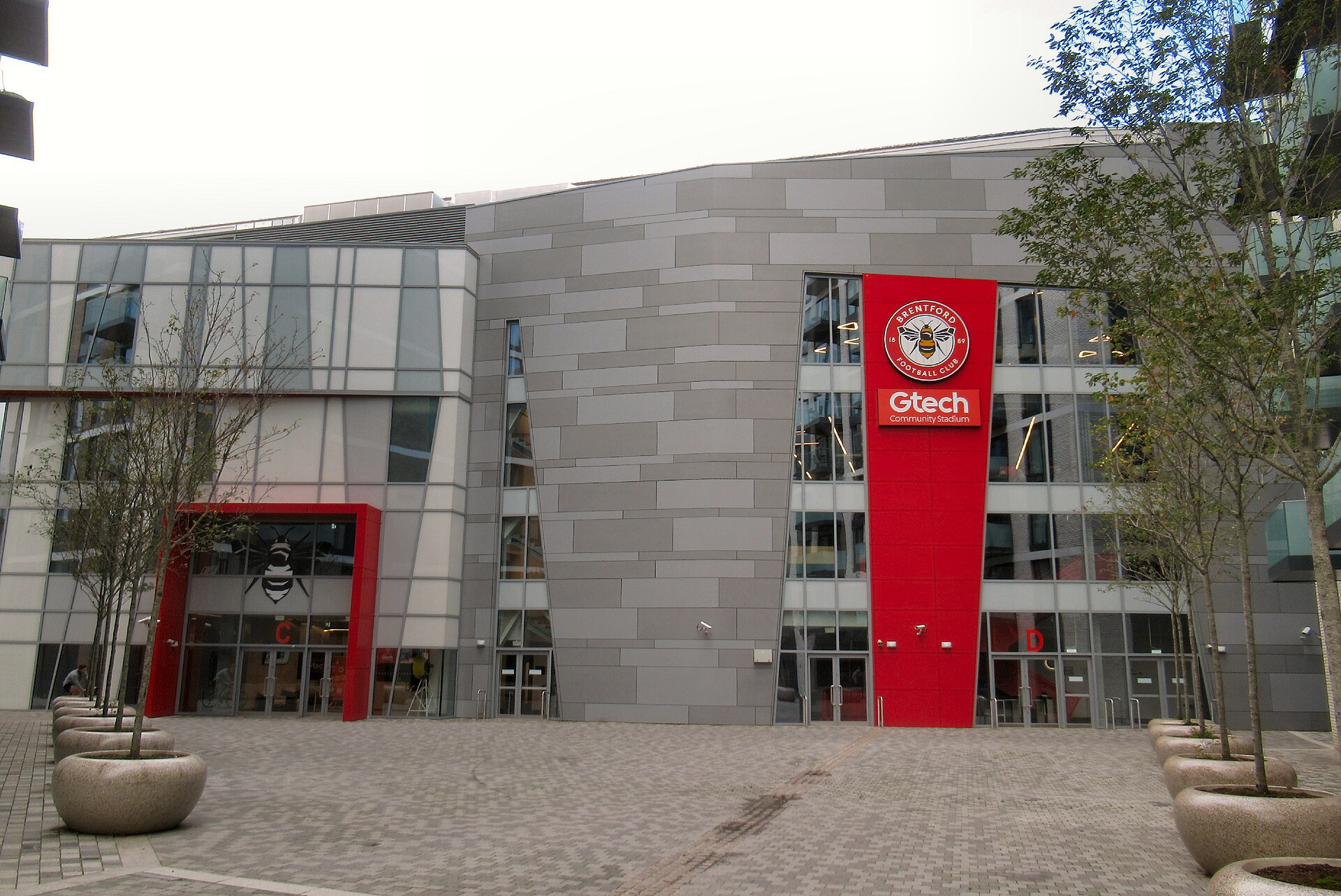 A fachada do Gtech Community Stadium em outubro de 2023, encaixado no triângulo de linhas férreas de Lionel Road.