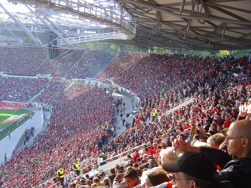 A Nordkurve tomada de vermelho, a arquibancada atrás do gol onde canta a torcida do 96.