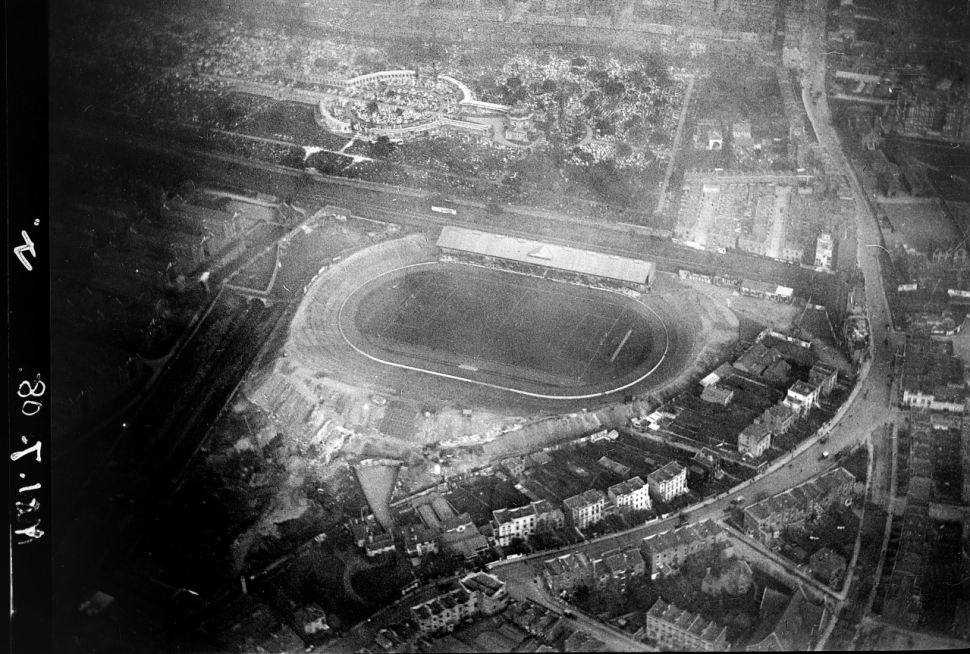 O Stamford Bridge do alto em 7 de novembro de 1909, com uma arquibancada coberta só de um lado e o resto do anel em degraus de terra.
